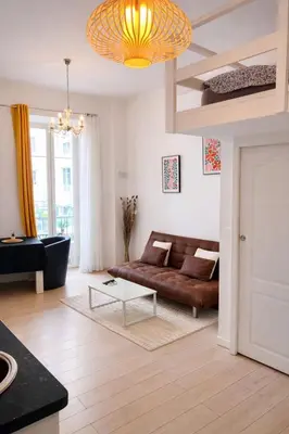 a couch in a living room with a map on the wall at Appartement central avec balcon in Nice