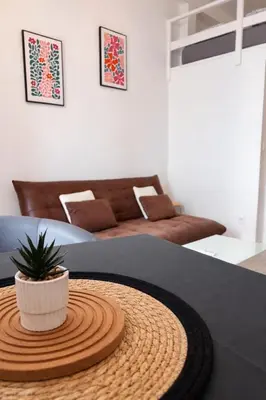 a dining room with a table and chairs and a window at Appartement central avec balcon in Nice
