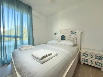 a bedroom with a white bed with towels on it at L'Elydris - Piscine Wifi Rooftop in Saint-Laurent-du-Var