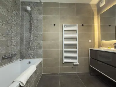 a bathroom with a shower and a tub and a sink at L'Elydris - Piscine Wifi Rooftop in Saint-Laurent-du-Var