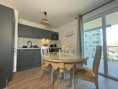 a kitchen and dining room with a table and chairs at L'Elydris - Piscine Wifi Rooftop in Saint-Laurent-du-Var