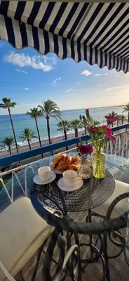 a table with a meal on a balcony with the beach at Luxe Apartements Azur in Nice