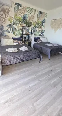 two beds in a room with a wall with plants at Luxe Apartements Azur in Nice
