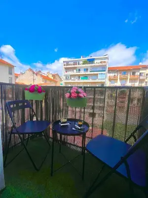 two chairs and two tables on a balcony with flowers at Charmant 2 pièces - Hyper Centre de Nice in Nice