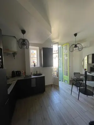 a kitchen and living room with a table and a dining room at Charmant 2 pièces - Hyper Centre de Nice in Nice