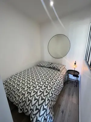 a bedroom with a bed and a mirror on the wall at Charmant 2 pièces - Hyper Centre de Nice in Nice