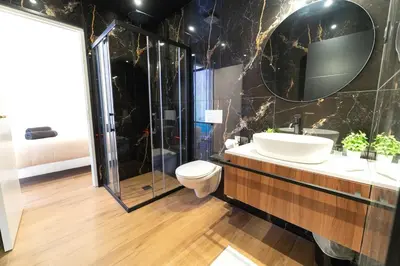 a bathroom with a toilet and a sink and a shower at Romantic suite with jacuzzi in La Trinité