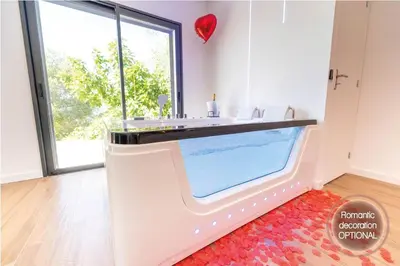 a bathroom with a sink and a large window at Romantic suite with jacuzzi in La Trinité