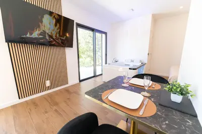 a living room with a dining table and a fireplace at Romantic suite with jacuzzi in La Trinité