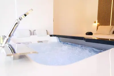 a bathroom with a tub with a sink at Romantic suite with jacuzzi in La Trinité