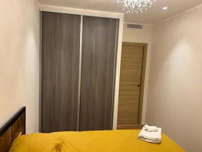 a bedroom with a yellow bed and a closet at LE PALAIS DIANE - Apt cosy, Moderne et Climatisé in Nice