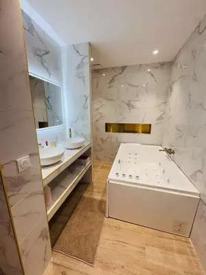 a bathroom with a tub and a sink at LE PALAIS DIANE - Apt cosy, Moderne et Climatisé in Nice