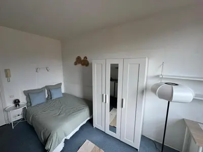 a small bedroom with a bed and a lamp at Bright studio in Nice - Mobility lease only - WIFI in Nice