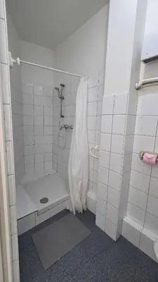 a white tiled bathroom with a shower and a tub at LX144 Bright & refined studio WIFI Mobility lease in Nice