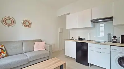 a living room with a couch and a kitchen at LX148 Charmant studio renove Tram - Bail mobilite in Nice