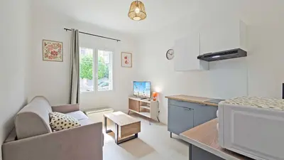 a kitchen and living room with a couch and a table at LX149 Studio lumineux fonctionnel - Bail mobilite in Nice