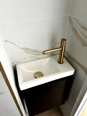 a white sink with a gold faucet in a bathroom at Appartement avec jardin - Front de mer St Laurent-du-Var in Saint-Laurent-du-Var
