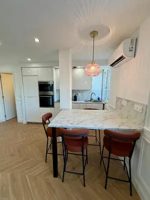 a kitchen with a table and chairs in a room at Appartement avec jardin - Front de mer St Laurent-du-Var in Saint-Laurent-du-Var