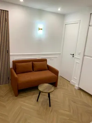 a living room with a couch and a table at Appartement avec jardin - Front de mer St Laurent-du-Var in Saint-Laurent-du-Var
