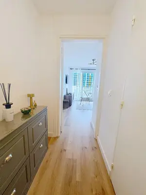 a kitchen with a dresser and a room with a hallway at Sunny studio on a high floor with terrace in Nice