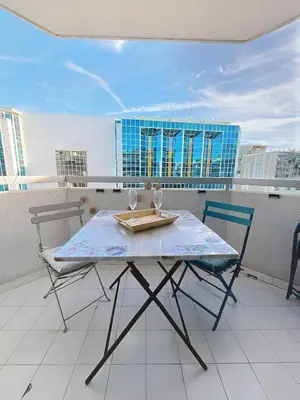 a table and two chairs on a balcony at Sunny studio on a high floor with terrace in Nice