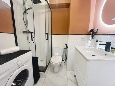 a bathroom with a toilet a sink and a washing machine at Sunny studio on a high floor with terrace in Nice