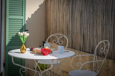 a table with a bowl of food and two chairs at louna in Beaulieu-sur-Mer