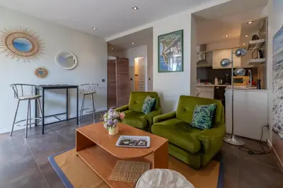 a living room with two green chairs and a table at louna in Beaulieu-sur-Mer