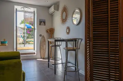 a living room with two stools and a mirror at louna in Beaulieu-sur-Mer