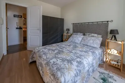 a bedroom with a bed with a blue and white bedspread at louna in Beaulieu-sur-Mer