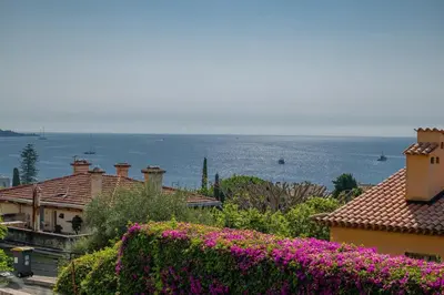 a view of the ocean from a house with flowers at louna in Beaulieu-sur-Mer