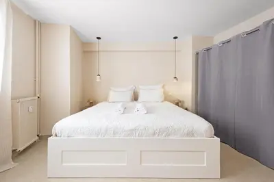 a bedroom with a white bed with two stuffed animals on it at Nice Saint Roch - Bel appartement rénové - EV in Nice