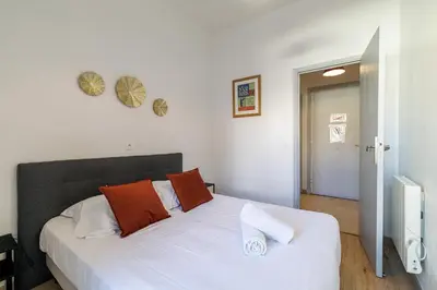 a bedroom with a bed with orange pillows and a window at Ultra Central 2 Bdr - AC & Balcony in Nice