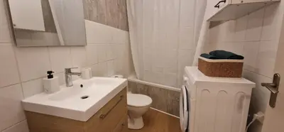 a white bathroom with a sink and a toilet at Le Cocon de la Prom in Nice