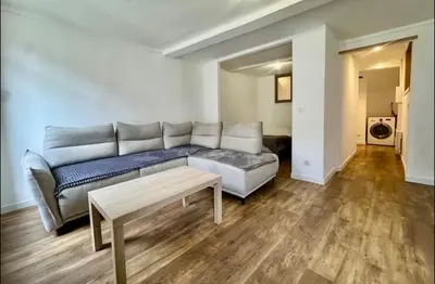 a living room with a couch and a table at Superbe deux pièces dans le vieux village in Saint-Laurent-du-Var