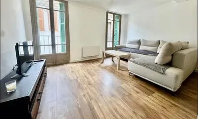 a living room with a couch and a table at Superbe deux pièces dans le vieux village in Saint-Laurent-du-Var