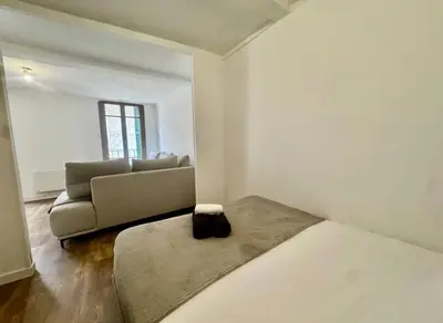 a living room with a couch and a bed at Superbe deux pièces dans le vieux village in Saint-Laurent-du-Var