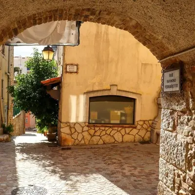 a stone building with an archway on a street at Jolie studio - 2 personnes - Saint laurent du Var in Saint-Laurent-du-Var