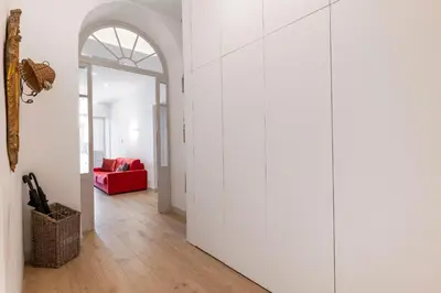 a hallway with white walls and a red couch at 