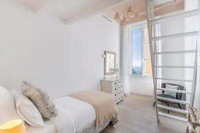 a bedroom with a white bed and a ladder at 