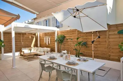 a white table with chairs and an umbrella on a patio at Nice Charm XXL Terrace in Nice