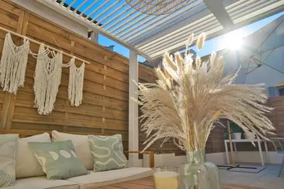a living room with a white couch and a vase with grass at Nice Charm XXL Terrace in Nice