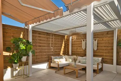 a pergola on a patio with a couch and a table at Nice Charm XXL Terrace in Nice