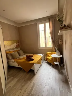 a bedroom with a bed and a table and a window at Perfectly located 1 bed apartment - Port of Nice in Nice