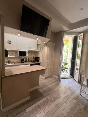 a kitchen with white cabinets and a flat screen tv at Perfectly located 1 bed apartment - Port of Nice in Nice