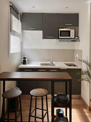 a kitchen with a counter with stools and a microwave at Bottero nice in Nice
