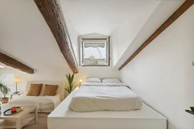 a white bedroom with a bed and a couch at Studio Place Masséna Vieux Nice - situation idéale in Nice