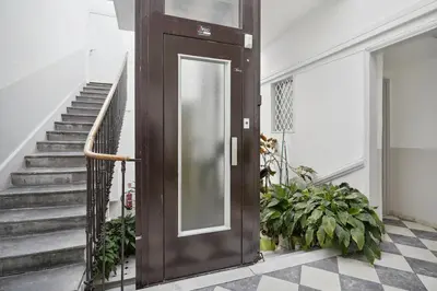 a large wooden door in a hallway with stairs at Studio Place Masséna Vieux Nice - situation idéale in Nice