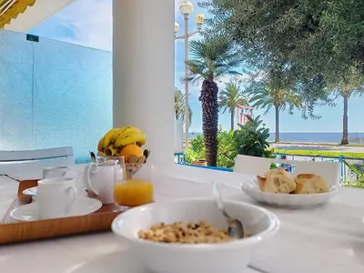 a bedroom with a bed and a table and chairs at Promenade des Anglais GARDEN SEA VIEW in Nice