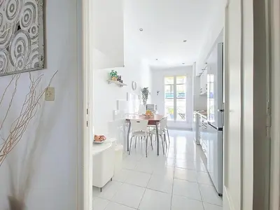 a large white room with a table and a vase at Promenade des Anglais GARDEN SEA VIEW in Nice